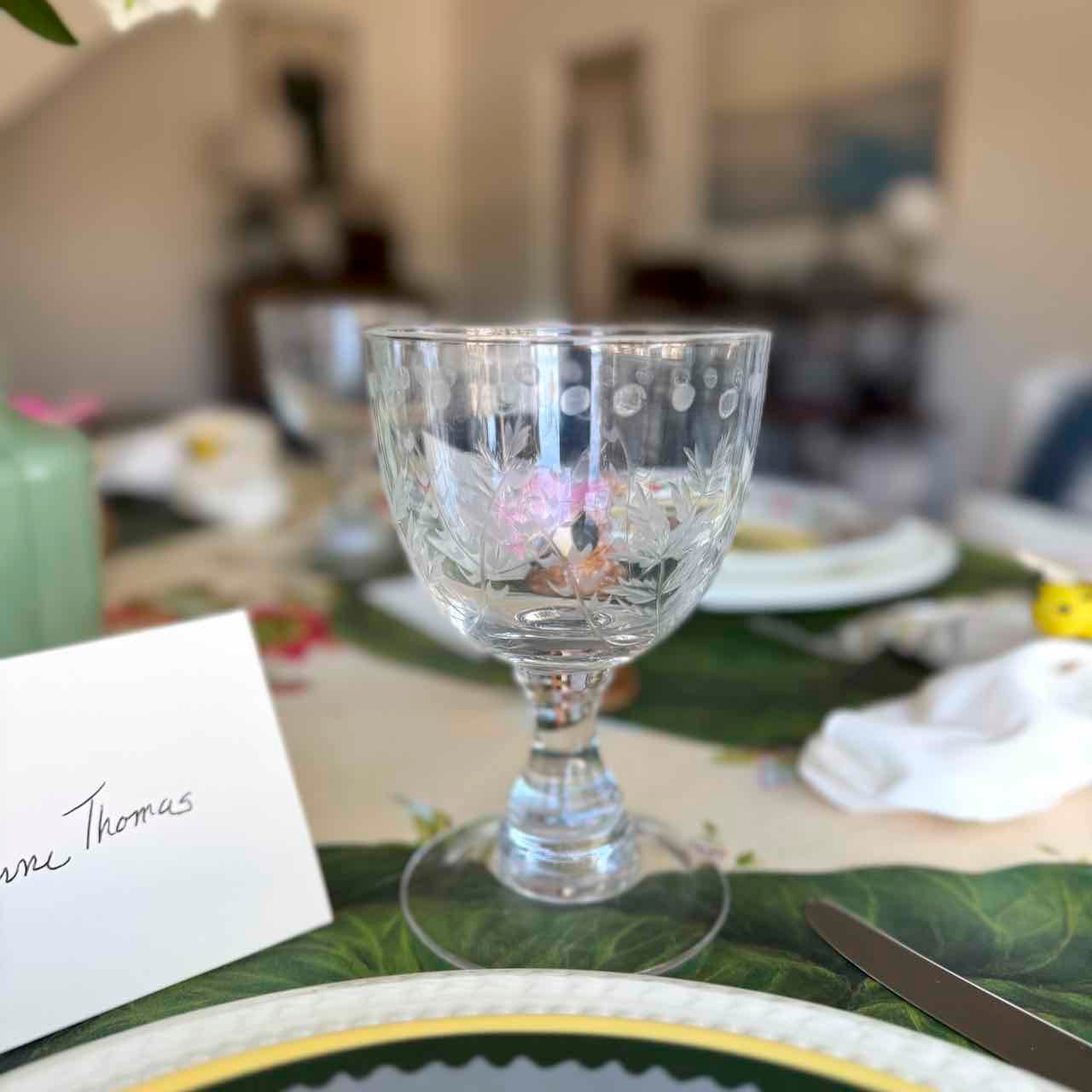 Decorative glass goblet on a table with place cards and cutlery