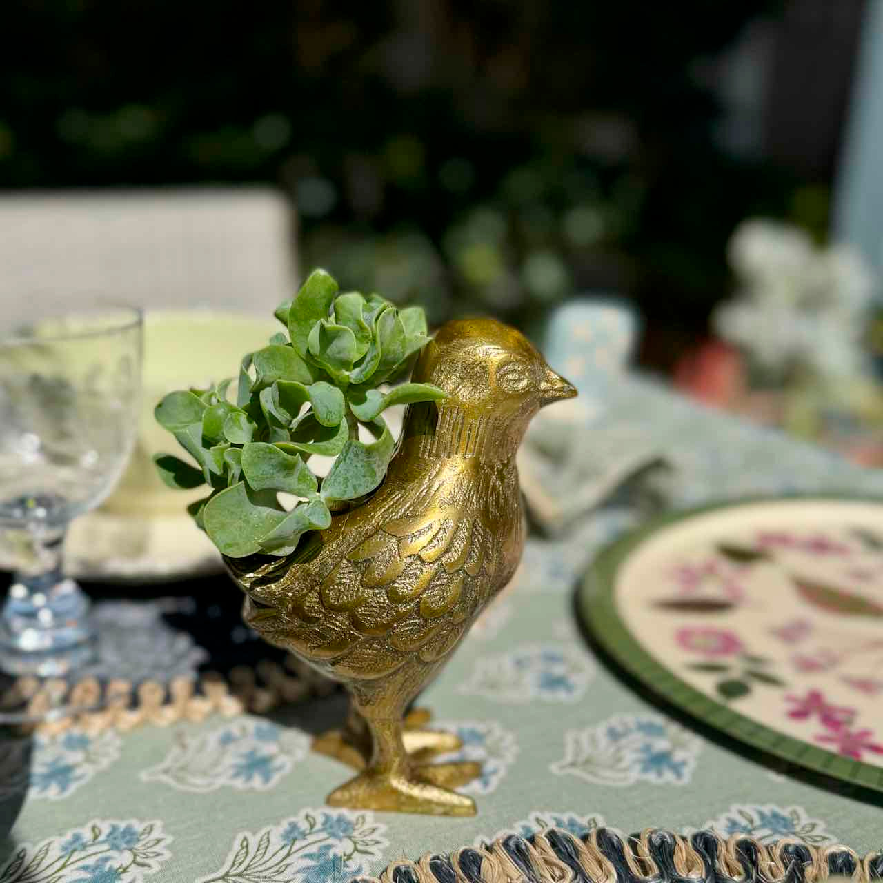 Gold bird-shaped planter with succulents on a decorative table