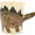 Ceramic mug shaped like a dinosaur with a beige background