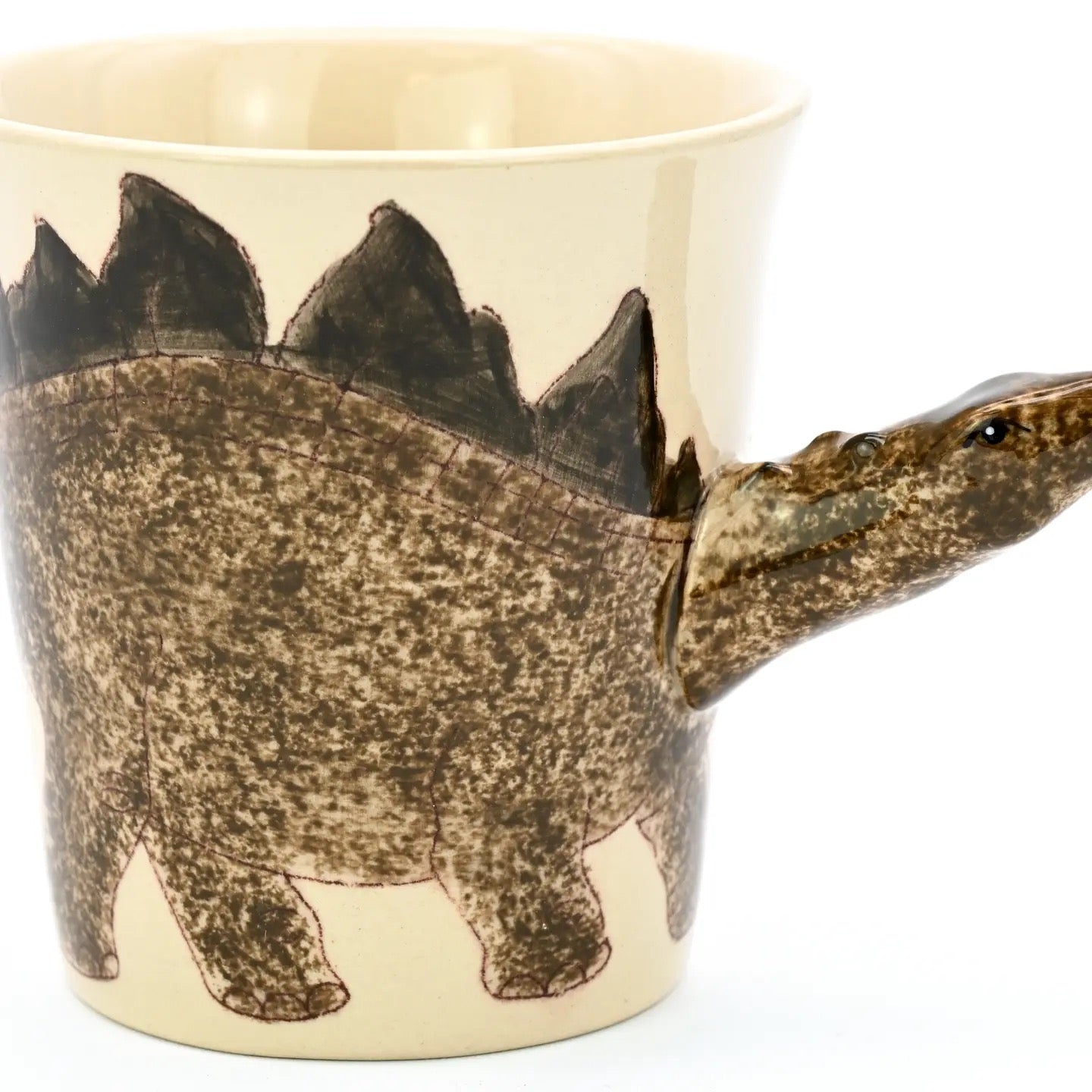 Ceramic mug shaped like a dinosaur with a beige background