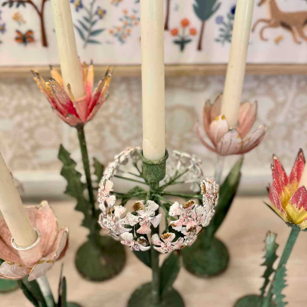 Decorative candle holder with floral design against a patterned wall