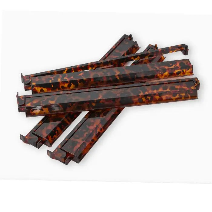 Six tortoiseshell-patterned rectangular plastic strips, likely replacement parts or craft components, arranged in a stack on a white background.