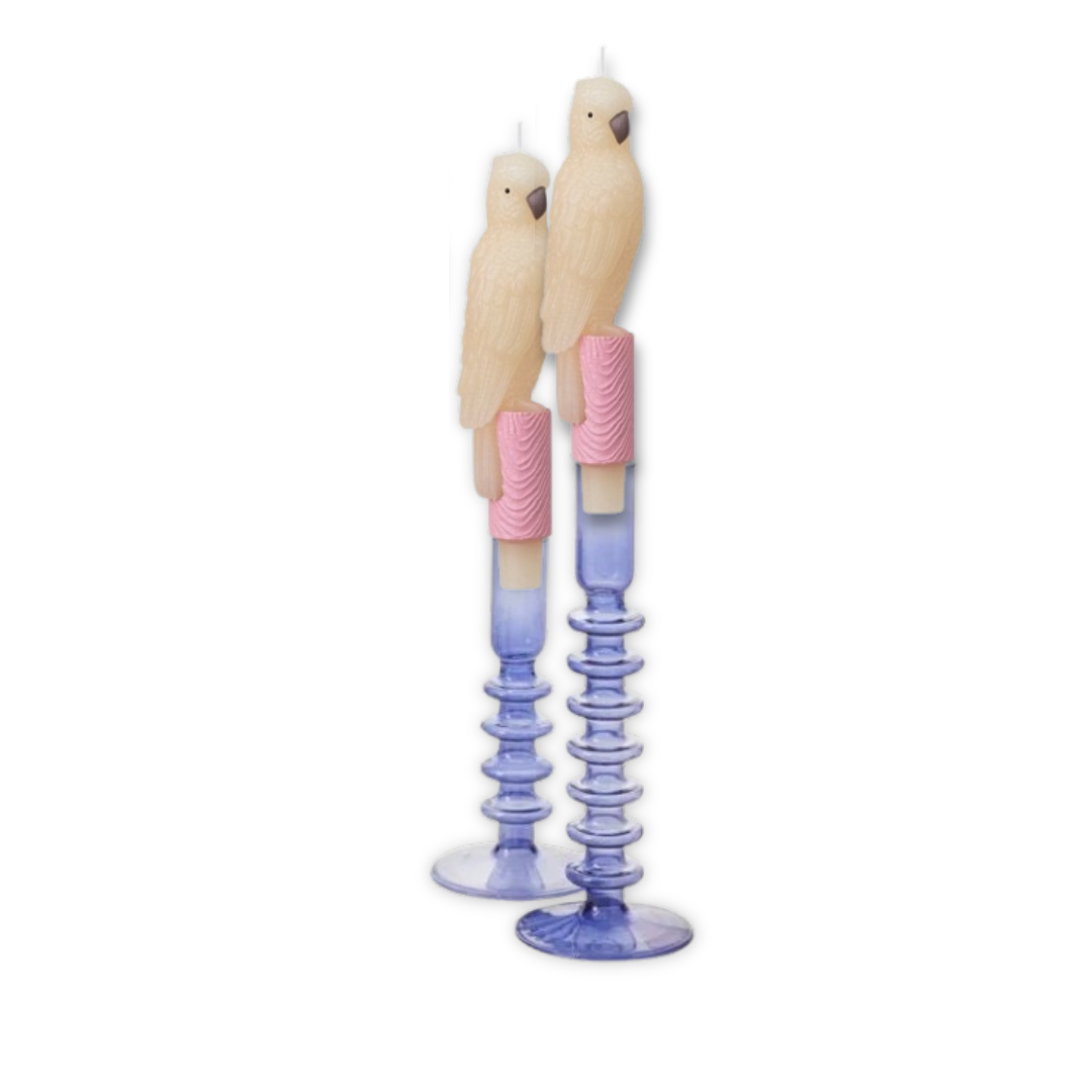 Two bird-shaped candles with pastel-colored candle holders on a white background