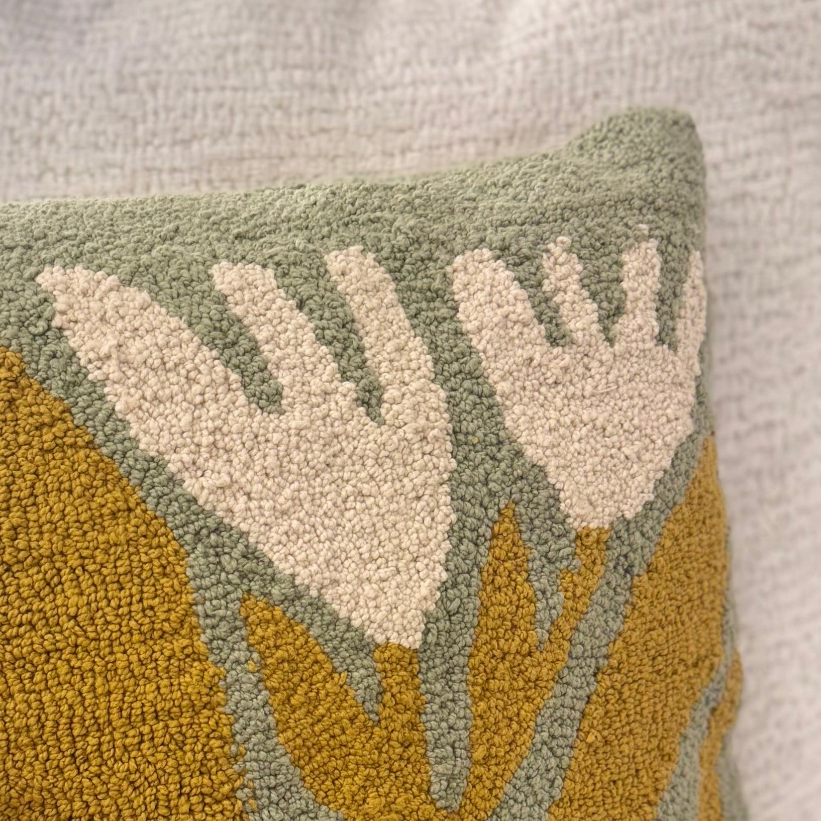 Textured pillow with leaf pattern on a neutral background