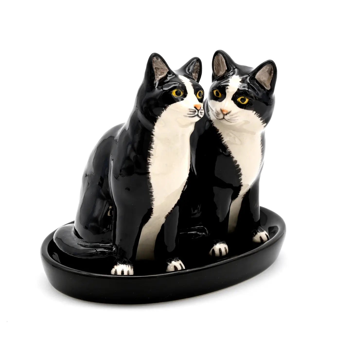 Ceramic sculpture of two black and white cats on a white background