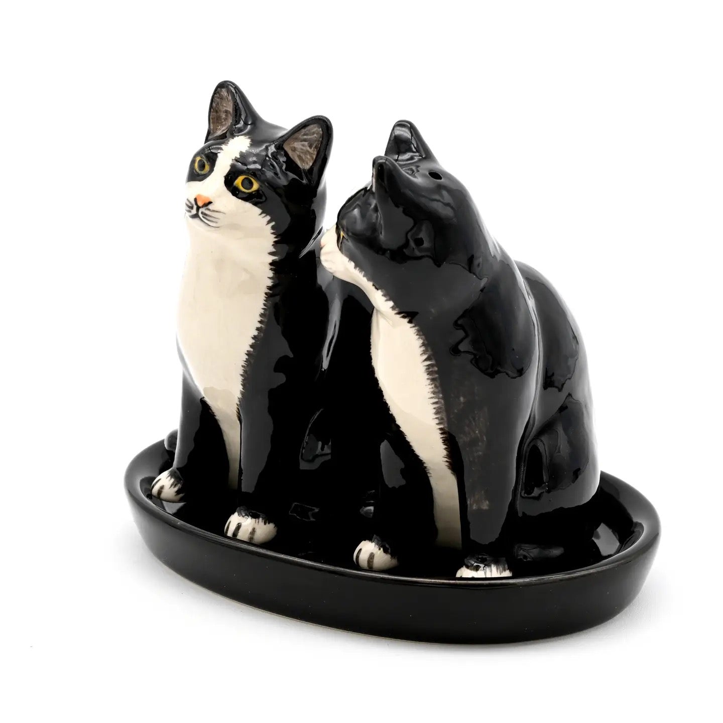 Ceramic sculpture of two black and white cats on a white background