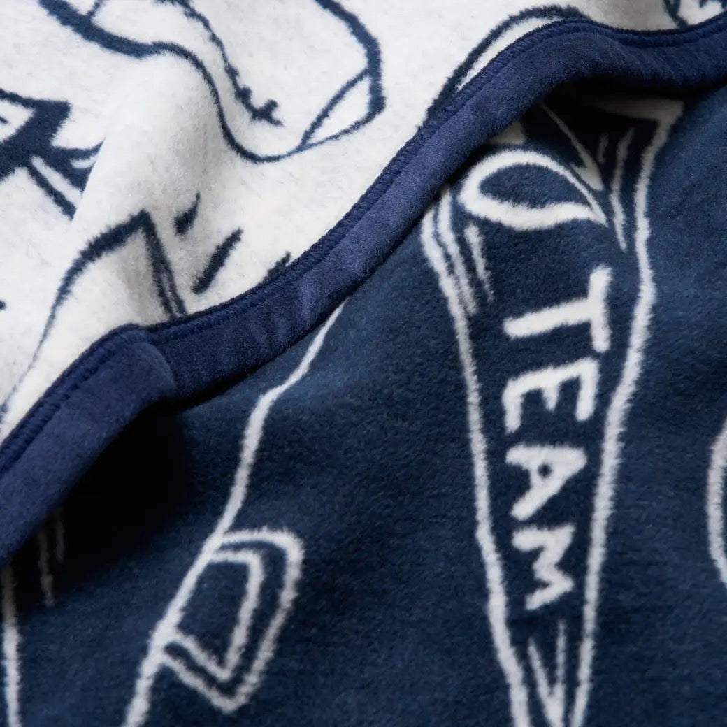 Close-up of a blue and white blanket with 'TEAM' text and logo.