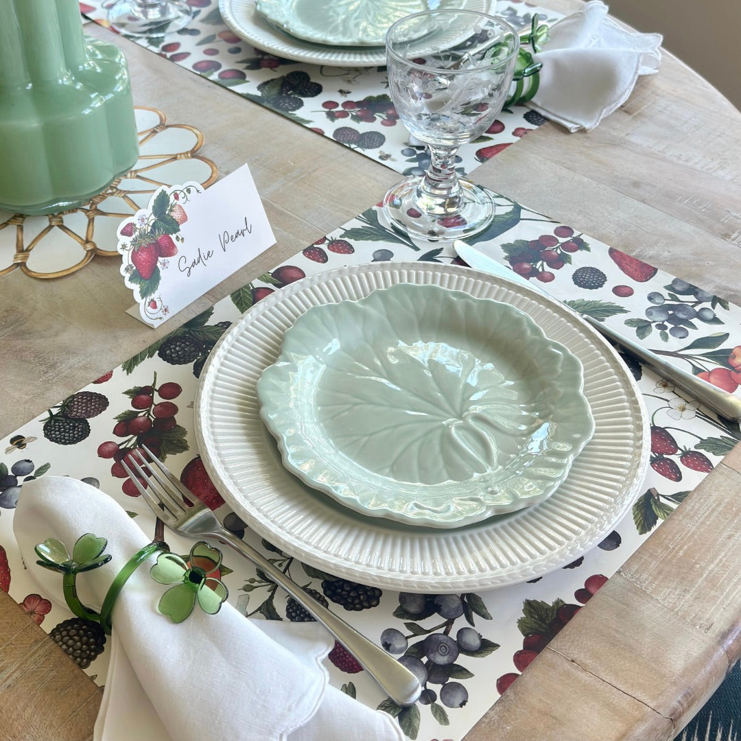 Dining table setting with ceramic plates, cutlery, and a decorative placemat.