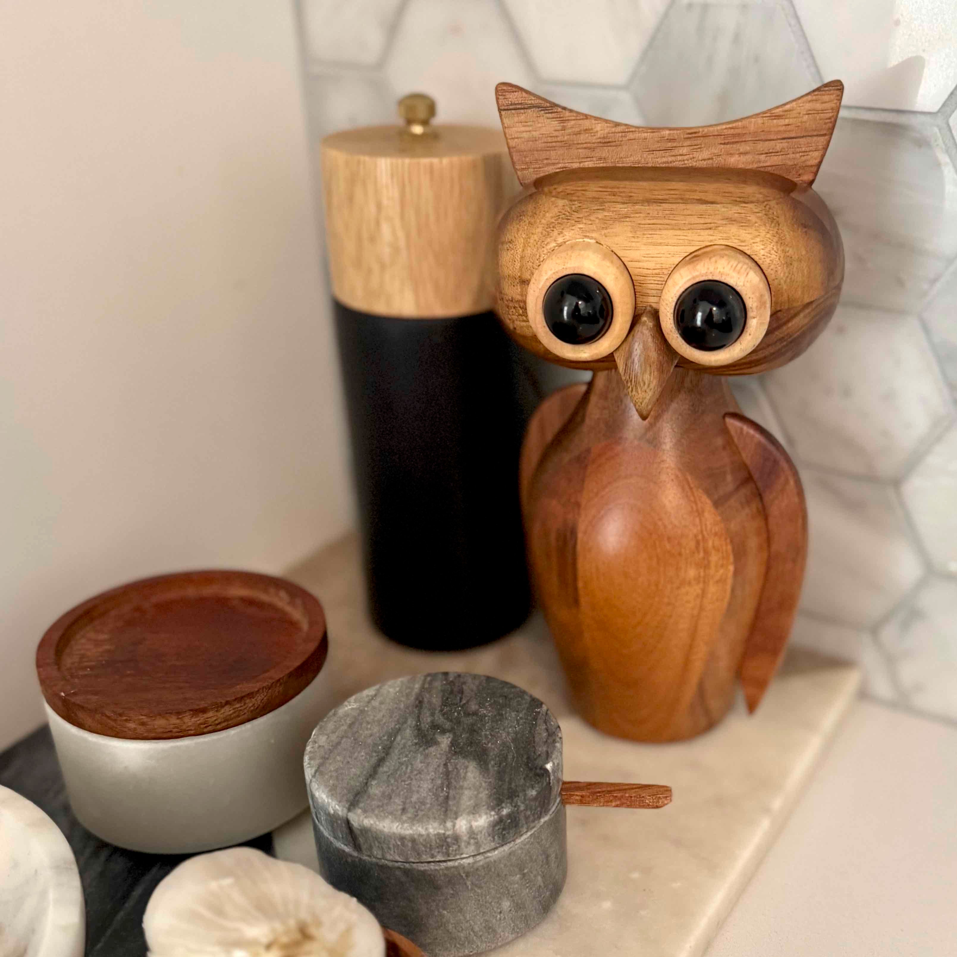 Wooden owl figurine on a shelf with other decorative items