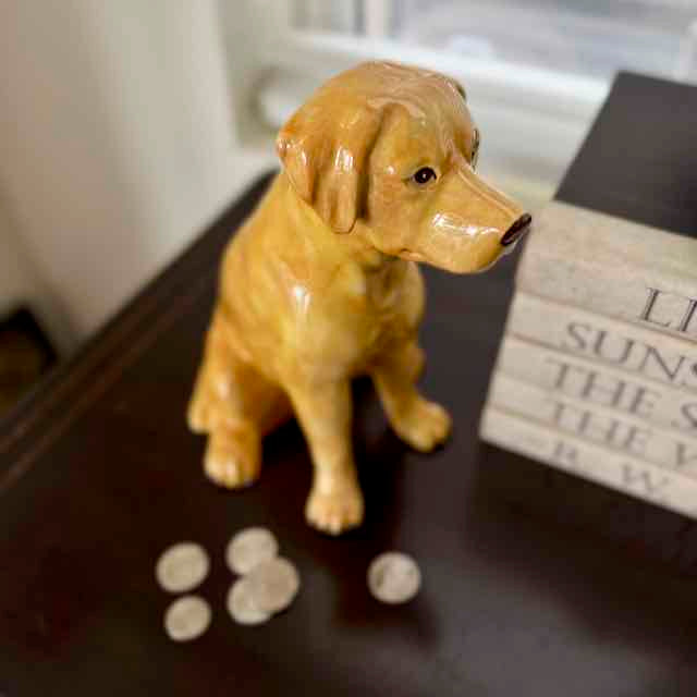 Dog-shaped decorative item on a surface with paw prints