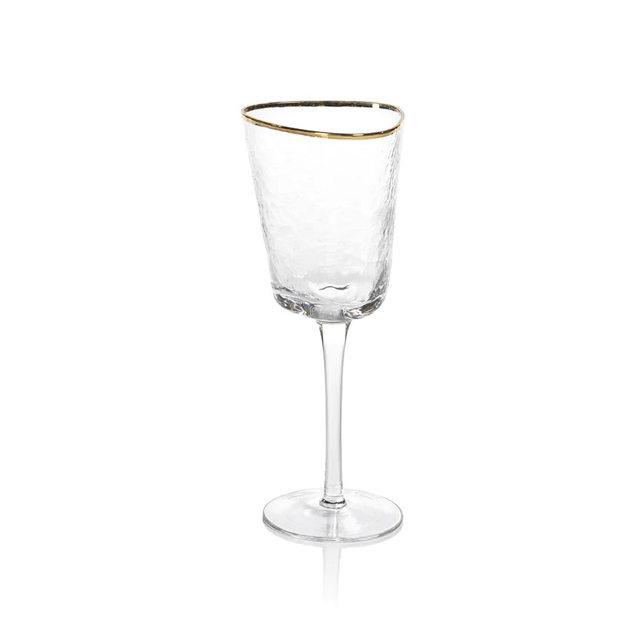 A clear triangular wine glass with a gold rim on the top edge.