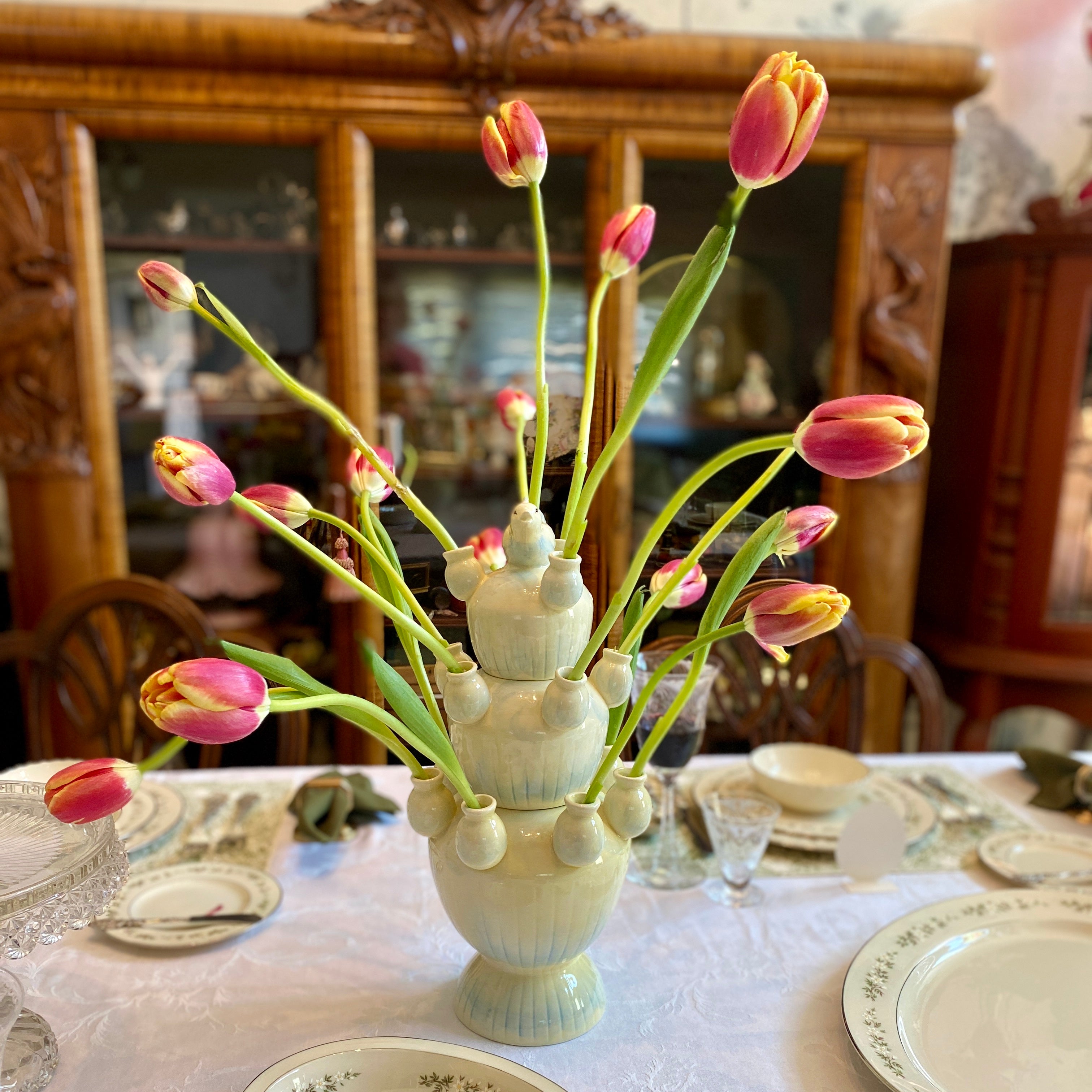 A tulipiere as a centerpiece on a dinner table.