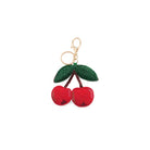 Cherry-shaped keychain with green leaves on a white background
