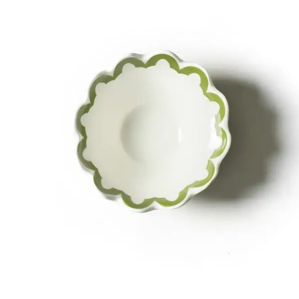 Small white bowl with green rim on a white background