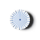 Round ceramic plate with blue radial pattern on a white background