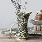 Ceramic pitcher with decorative patterns on a wooden surface