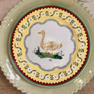 Decorative plate with a swan design on a floral patterned border