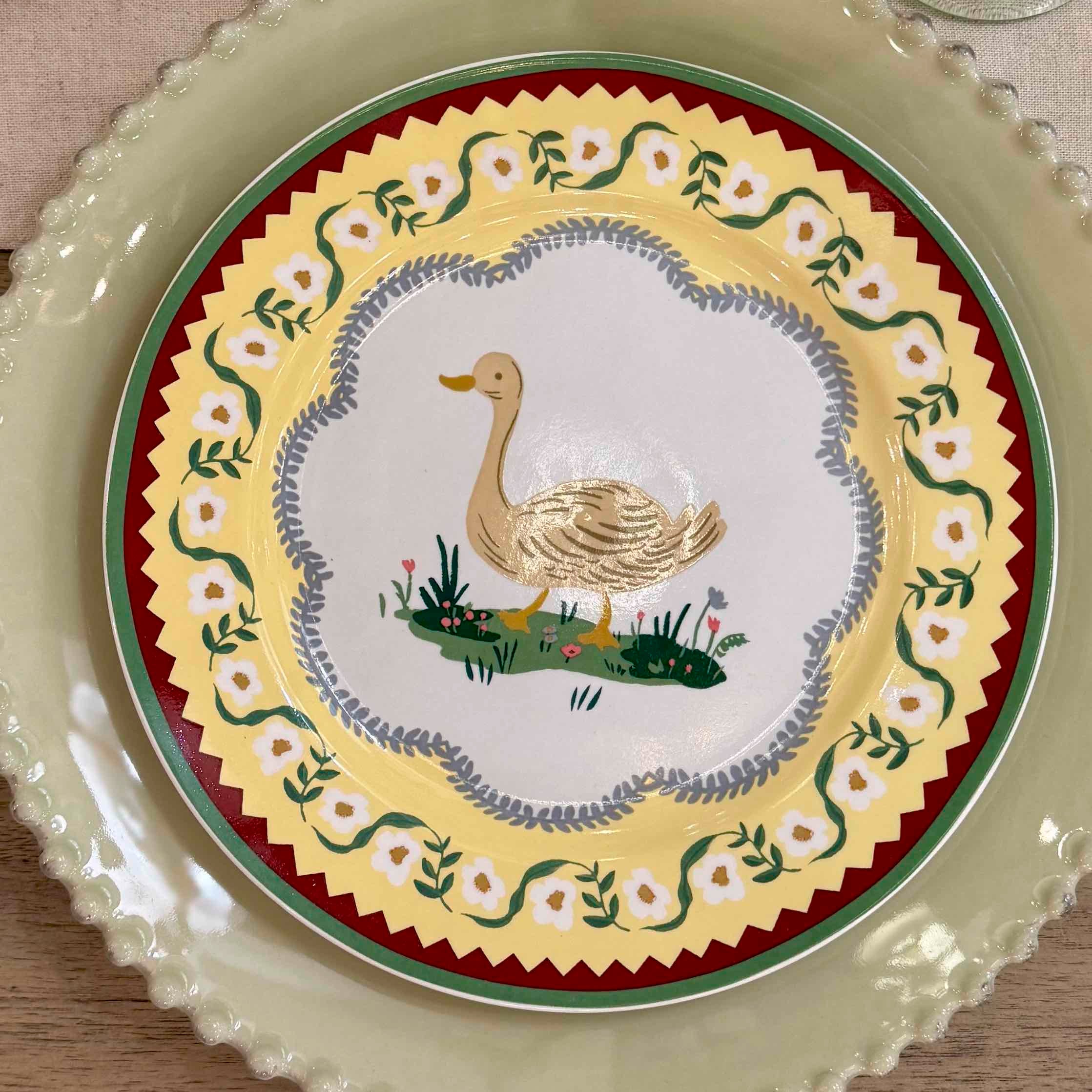 Decorative plate with a swan design on a floral patterned border