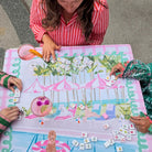 People playing a board game on a colorful tablecloth with a beach theme.