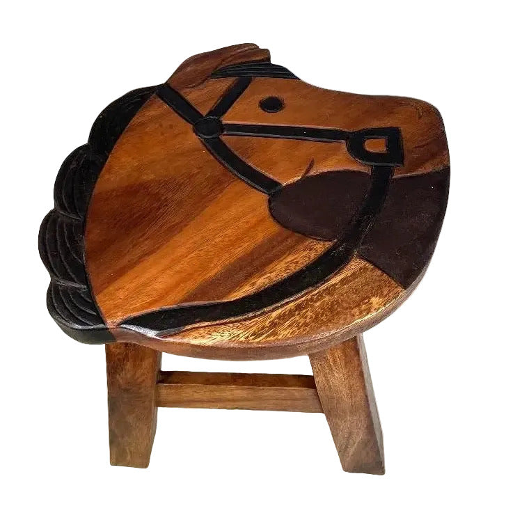 A small wooden stool shaped like a horse head, with a warm medium-brown wood finish and dark brown to black painted details outlining the horse face and mane, set against a plain white background.
