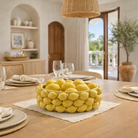 Bowl of lemons on a dining table with a blurred background