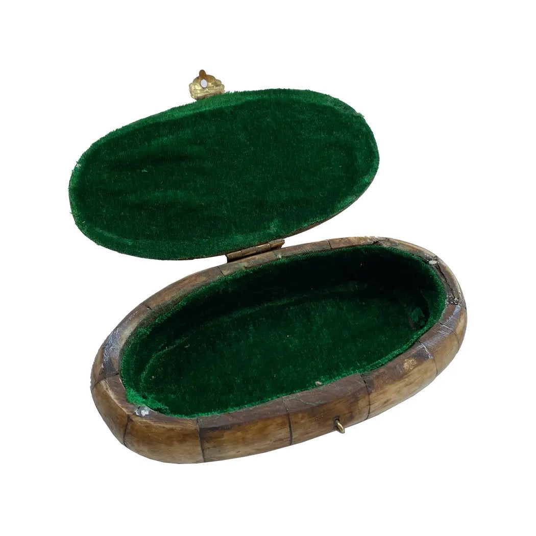 Wooden jewelry box with green velvet interior on a white background