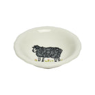A small white ceramic bowl featuring a hand-painted black sheep illustration with tiny yellow flowers along the bottom edge, set against a plain white background.