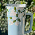 Tumbler with floral design on a light blue background