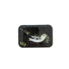 A rectangular tin with rounded corners featuring an illustration of a small white bird with black and brown markings holding green leaves, placed on a light wood surface.