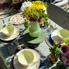 Decorative table setting with floral arrangements and place settings on a patio table.