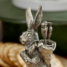Silver rabbit figurine with quiver and arrows on a blurred background