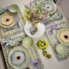 Decorative table setting with floral centerpieces and patterned placemats.