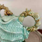 Decorative ceramic shell with starfish and shell design on a plain background