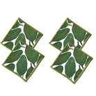 Two green leaf-patterned coasters on a white background