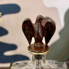 Decorative bottle stopper with an eagle design on a glass bottle.