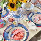 Decorative table setting with patriotic elements, including plates, napkins, and a cake.