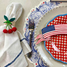 Dinner setting with American flag-themed plate, napkin, and cutlery on a table.
