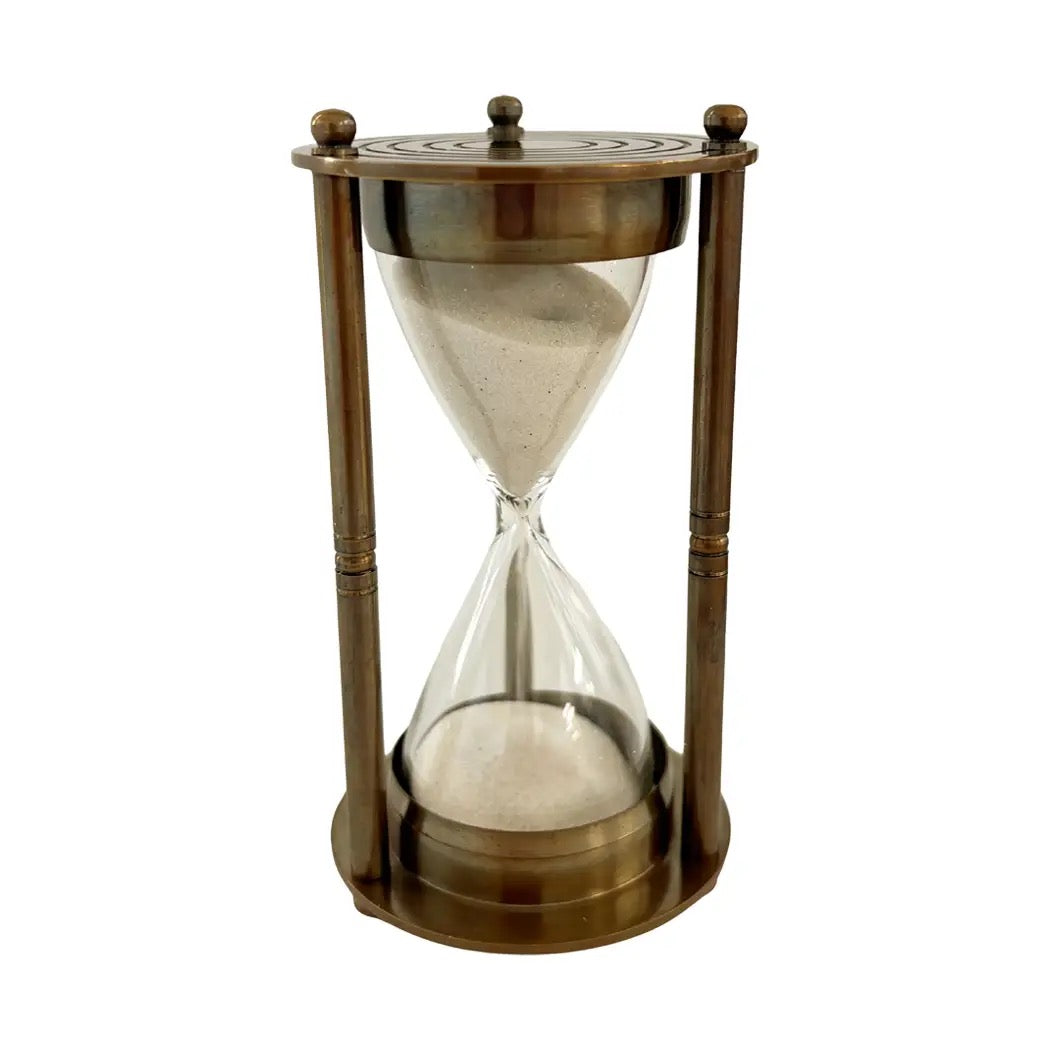 A classic hourglass with a bronze-finished metal frame and clear glass chambers containing sand, shown against a plain white background.