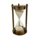 A classic hourglass with a bronze-finished metal frame and clear glass chambers containing sand, shown against a plain white background.