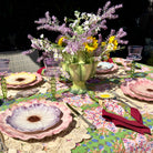 Decorative table setting with floral centerpiece, colorful plates, and patterned tablecloth.