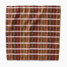 Plaid fabric with red, brown, and beige stripes on a white background