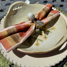 Decorative napkin with a decorative pin on a ceramic plate