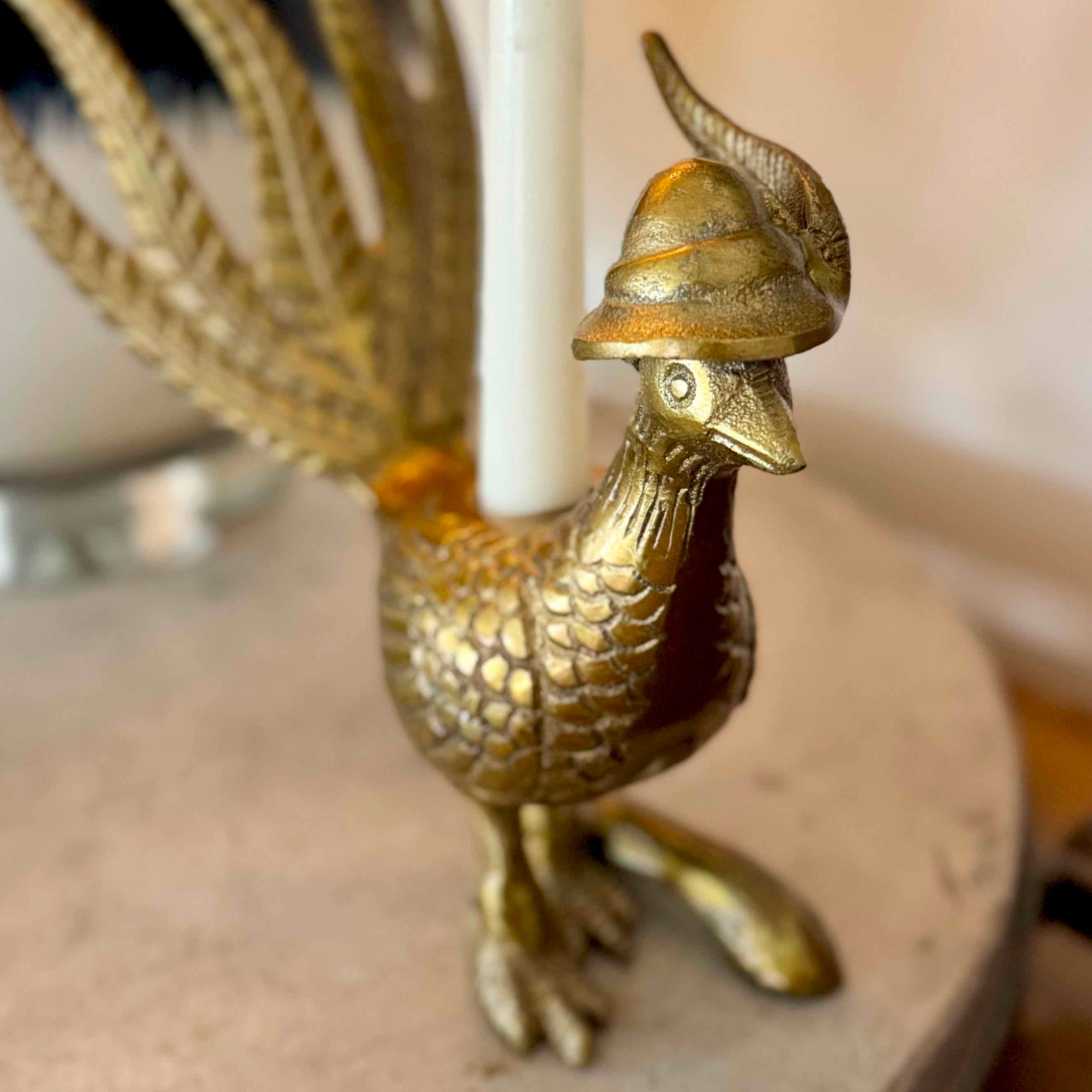 Gold dragon candle holder with a white candle inside on a wooden surface.