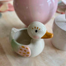 Ceramic duck-shaped container on a wooden surface