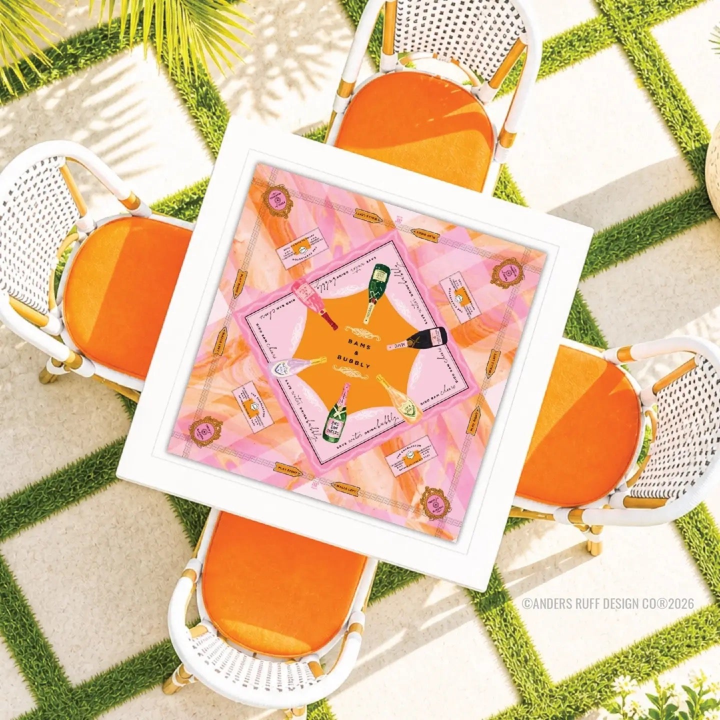 Decorative placemat with a pink design on a table surrounded by orange chairs.