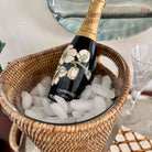 Perrier-Joué champagne bottle in a basket of ice with glasses in the background