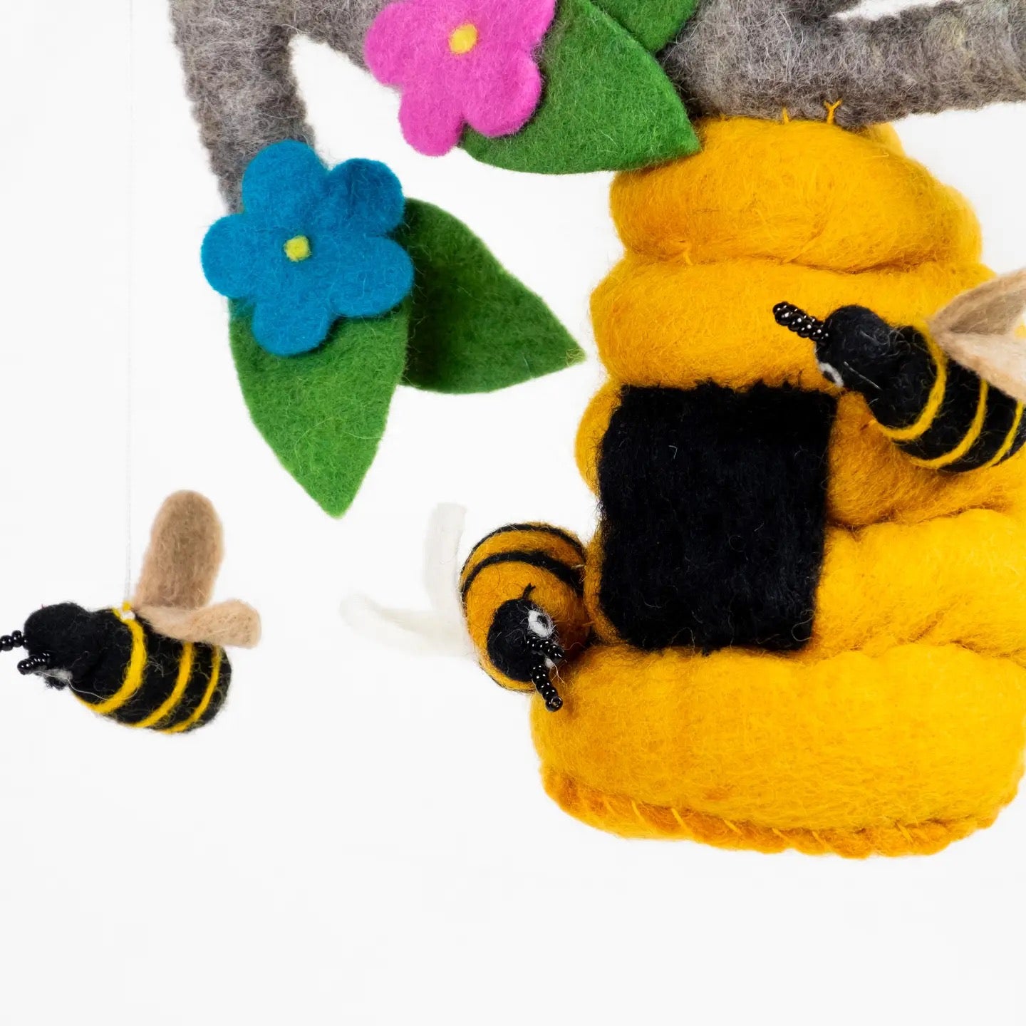 Felt bee hive with bees and flowers on a white background