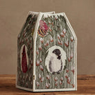 Decorative birdhouse with illustrations on a wooden surface and brown background