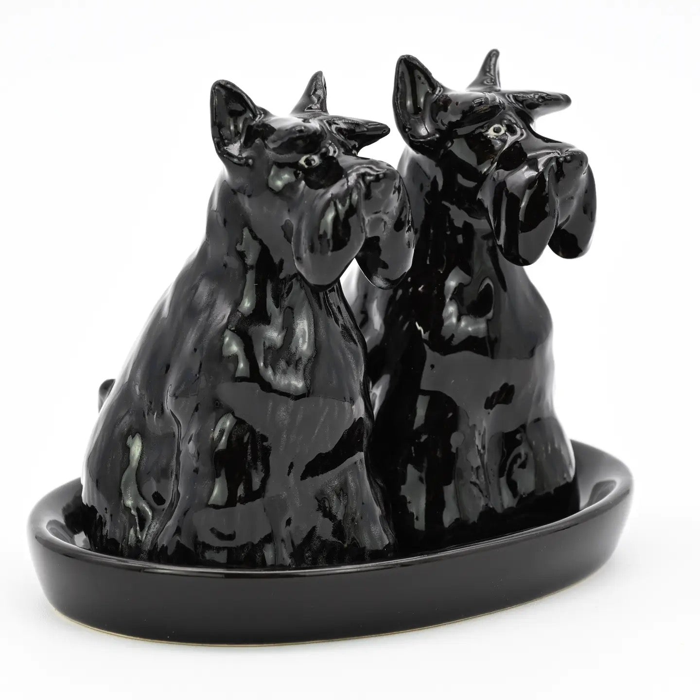 Black ceramic dog figurine on a white background