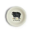 A round off-white ceramic dish with a scalloped rim, featuring a black hand-drawn sheep illustration and the text 'of the family' in black script, set against a plain white background.